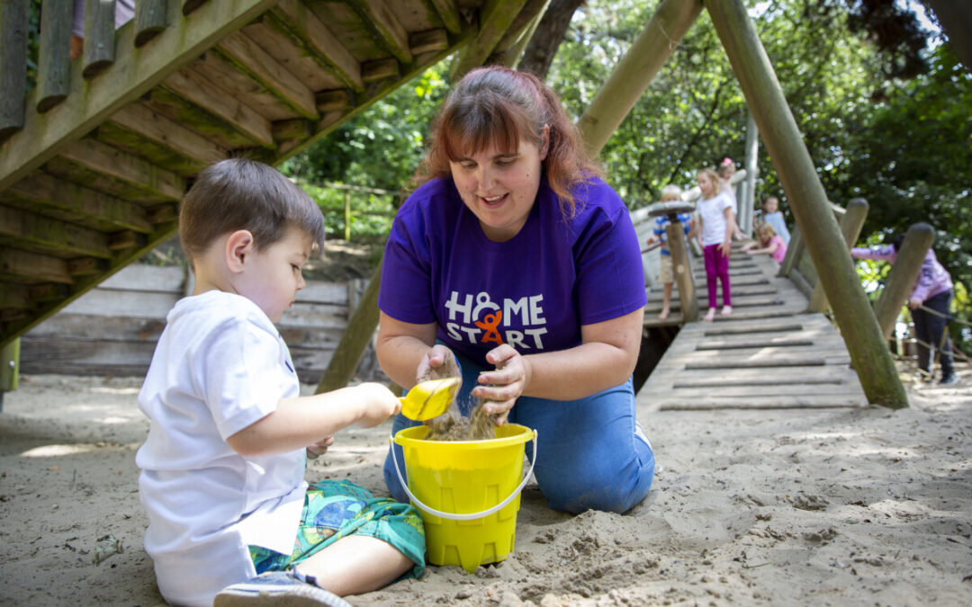 Homestart volunteer and child build a sandcastle